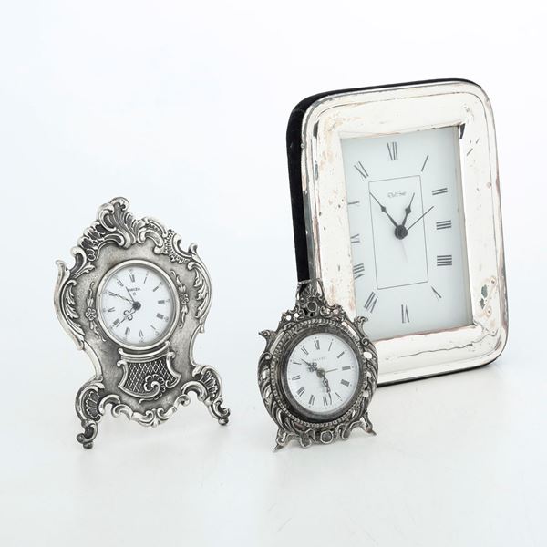 Tre orologi da tavolo con cornici in argento. Differenti manifatture del XX-XXI secolo