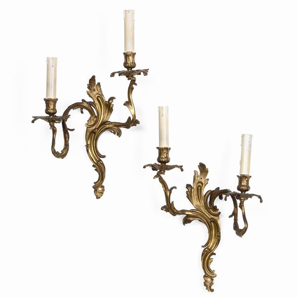 Coppia di appliques a due luci in bronzo dorato. XIX-XX secolo