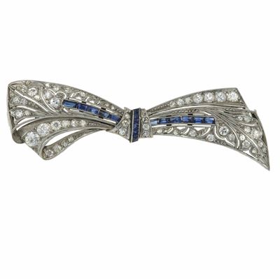 Spilla fiocco, diamanti e zaffiri, in oro bianco 750/1000