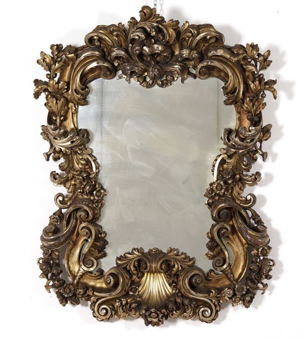 Specchiera in legno dorato e riccamente intagliato. XX secolo