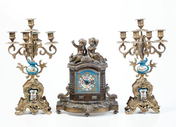 Trittico composto da pendola da tavolo e coppia di candelabri. Francia XX secolo