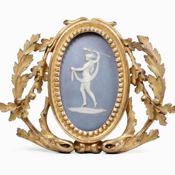 Piccola cornice in legno intagliato e dorato con bassorilievo in bisquit. XIX secolo