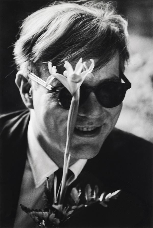 Andy Warhol (with flower, smiling)