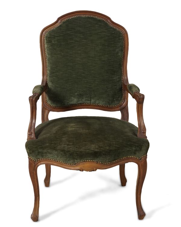 Poltrona in legno intagliato rivestita in velluto verde. XIX secolo