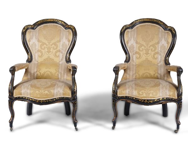 Coppia di poltrone in legno ebanizzato con decori dorati. XIX secolo