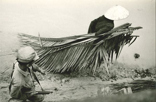 Senza titolo (Vietnam, un prigioniero trascina foglie di palme per costruire capanne)