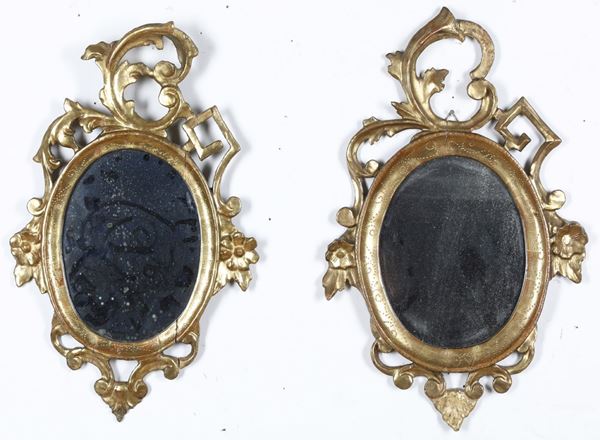 Coppia di specchiere ovali in legno intagliato e dorato. XIX secolo
