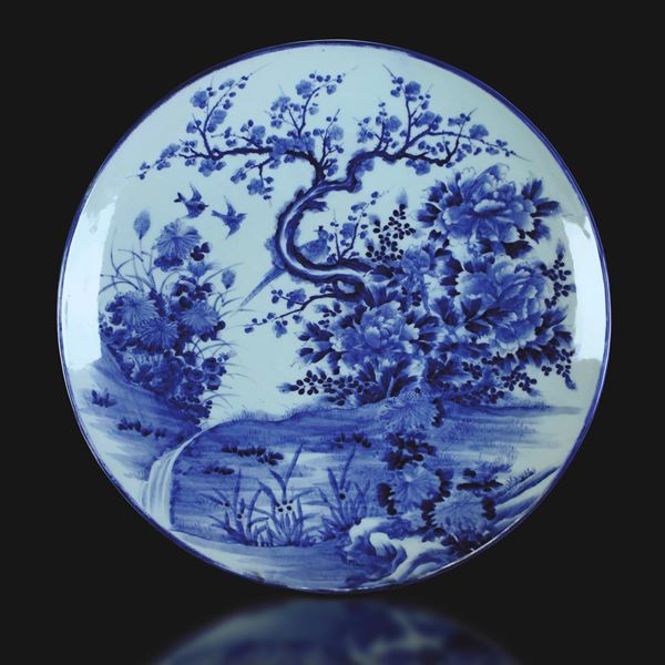 Grande piatto in porcellana Arita bianca e blu con decoro naturalistico e iscrizioni sul retro, Giappone, periodo Meiji (1868-1912)