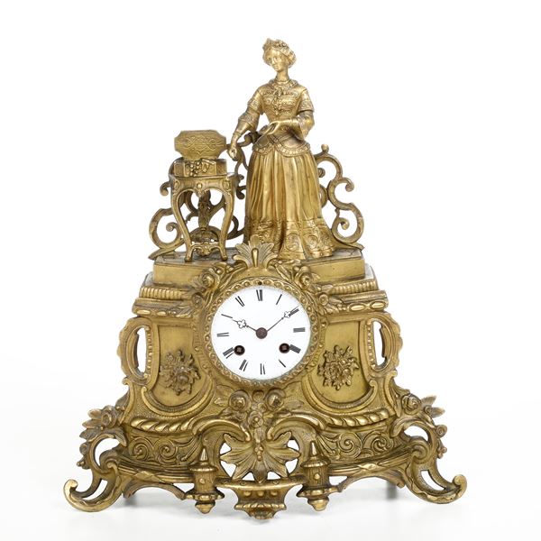 Pendola romantica, in bronzo dorato con cassa mossa sormontata da fanciulla stante in prossimità di un tavolino con scrigno colmo di gioielli, Francia XIX secolo