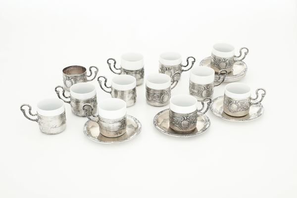 Lotto composto da 12 piattini caffe, 11 porta tazzine in argento e 10 tazzine in porcellana. Argenteria italiana del XX secolo