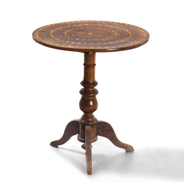 Tavolino tondo in legno intagliato e legno lastronato ed intarsiato. XX secolo