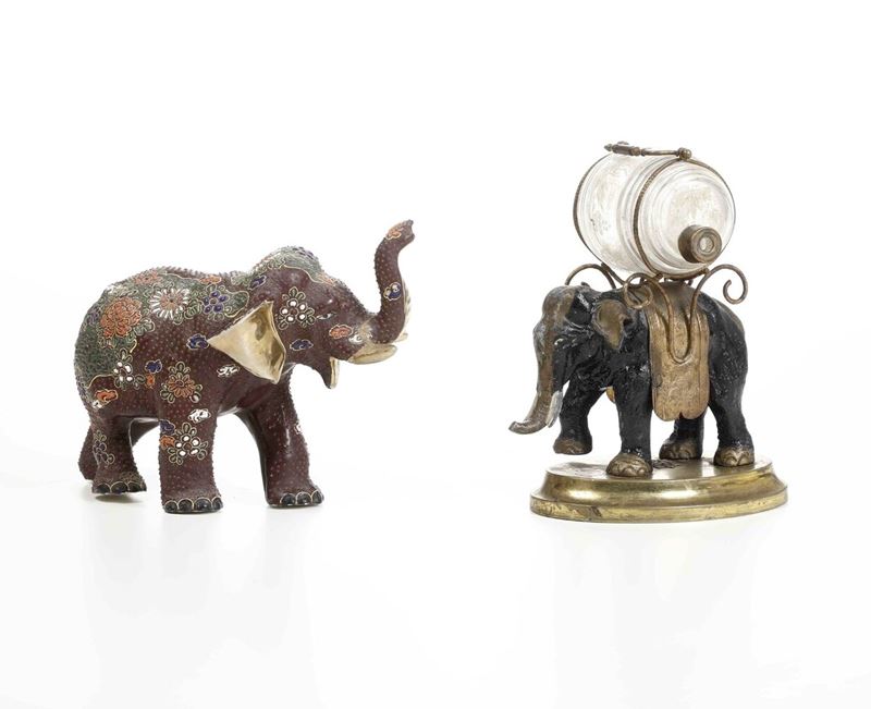 Due elefanti uno in porcellana dipinta (XX secolo) e uno in metallo con barilotto in vetro decorato  - Auction Antique - Cambi Casa d'Aste