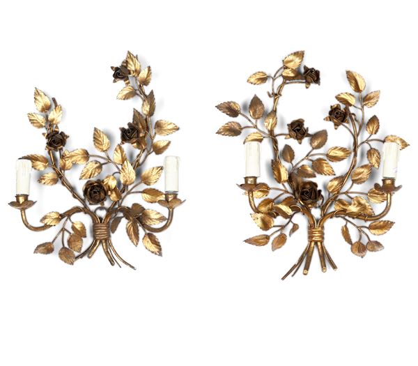 Coppia di appliques a due luci in metallo dorato. XIX-XX secolo