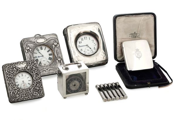 Quattro orologi da tavolo, un porta penny e un portasigarette. Inghilterra XX secolo (Birmingham, Chester, Londra), differenti manifatture.