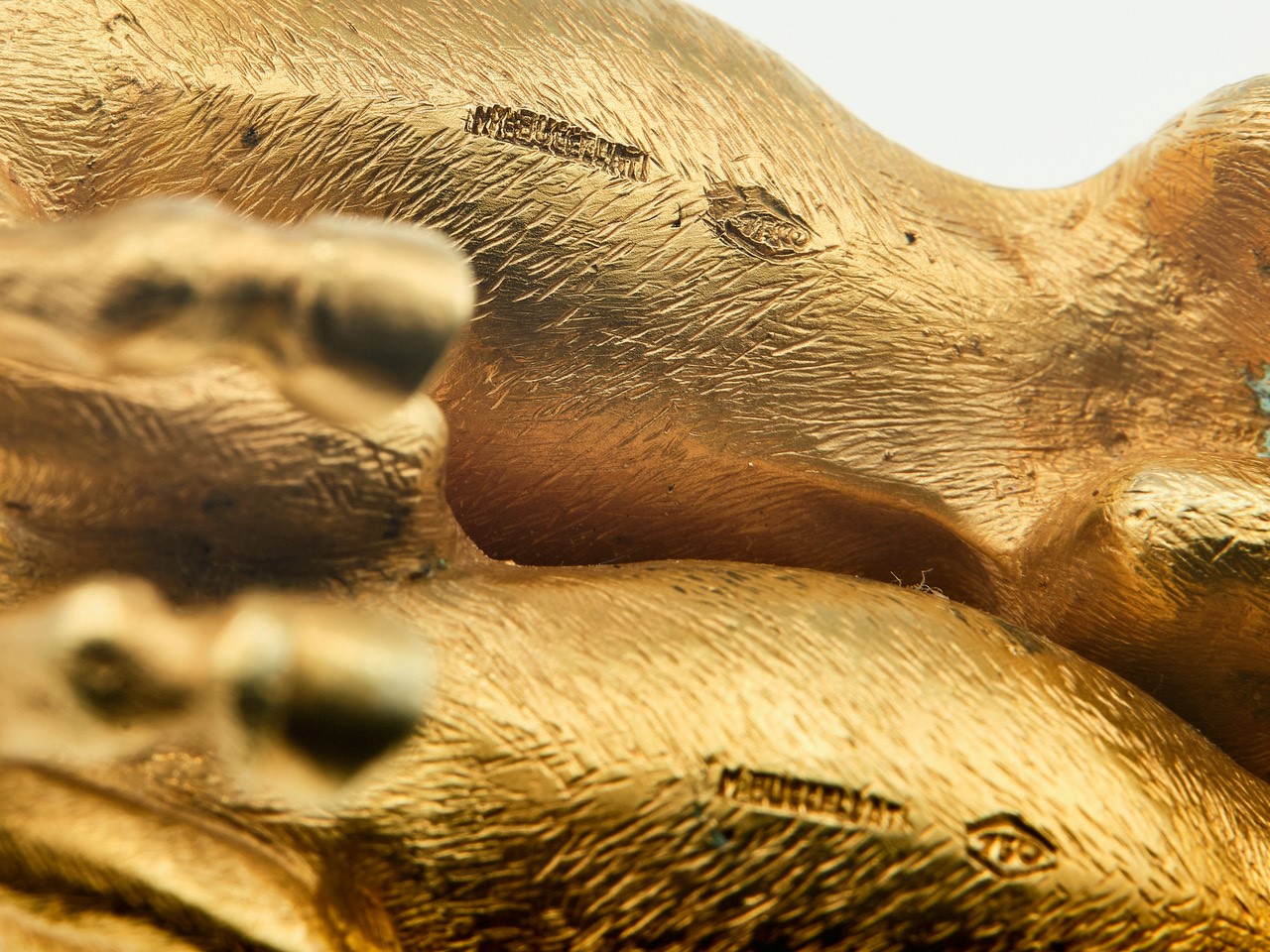 Scultura raffigurante “Due cavalli”, oro giallo 750/1000 su base in pietra