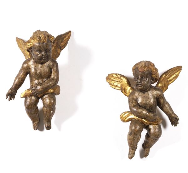 Coppia di sculture di angeli in legno dipinto e dorato. XIX secolo