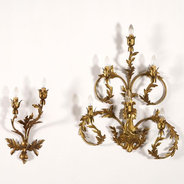 Due applique in metallo dorato, una a sei fiamme e una a due fiamme decorate a racemi fogliati, XX secolo
