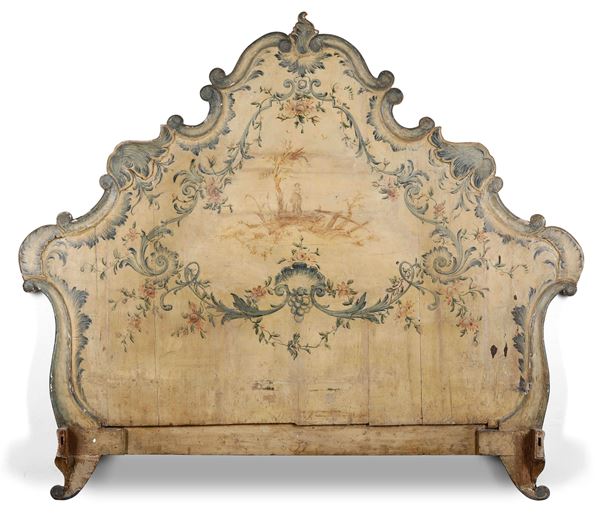 Testiera in legno intagliato e laccato a paesaggio con figura entro cartella di volute fogliate. XIX secolo