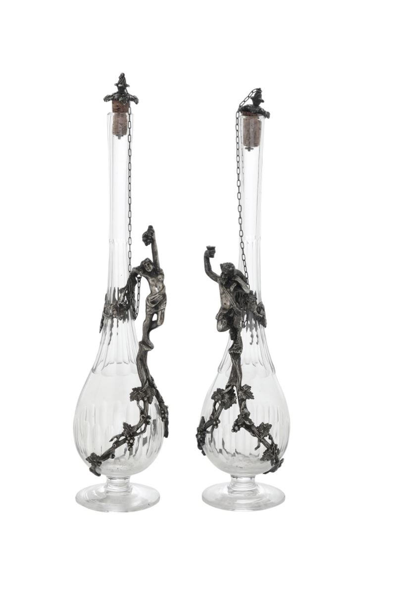 Due bottiglie in cristallo con manici a figure maschili in metallo. XX secolo.  - Asta Argenti - Cambi Casa d'Aste