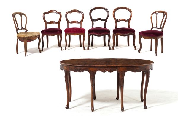 Tavolo allungabile in noce intagliato con sei sedie. XIX secolo