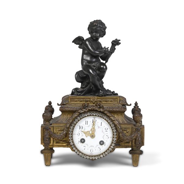 Pendola da tavolo in metallo dorato e patinato. XX secolo