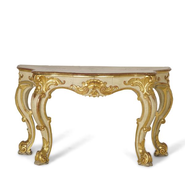 Consolle di forma mossa in legno intagliato, laccato e dorato. XX secolo