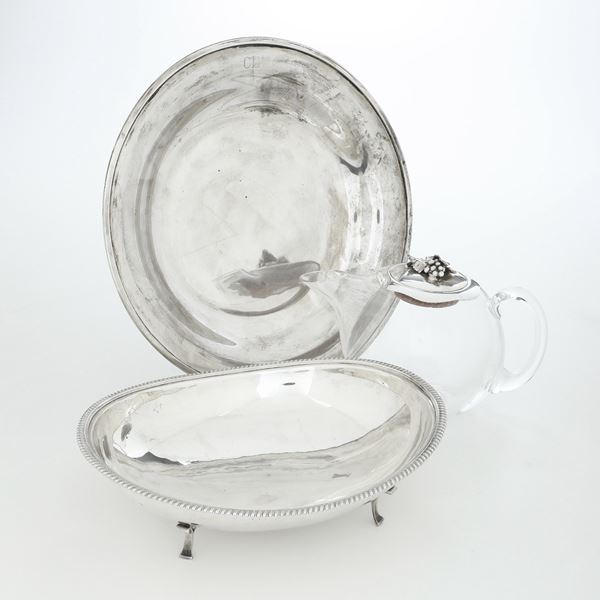 Piatto, centrotavola con piedini e bottiglia con tappo in argento. Argenteria italiana del XX secolo