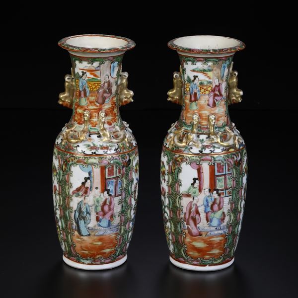 Coppia di vasi in porcellana Canton, raffigurante scena di corte entro riserve, decori floreali e figure di draghetti a rilievo, anse sagomate dorate a forma di Cane di Pho, Cina, Dinastia Qing, XIX secolo