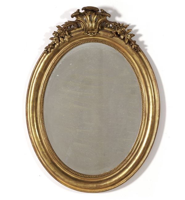 Specchiera ovale intagliata e dorata. XIX-XX secolo