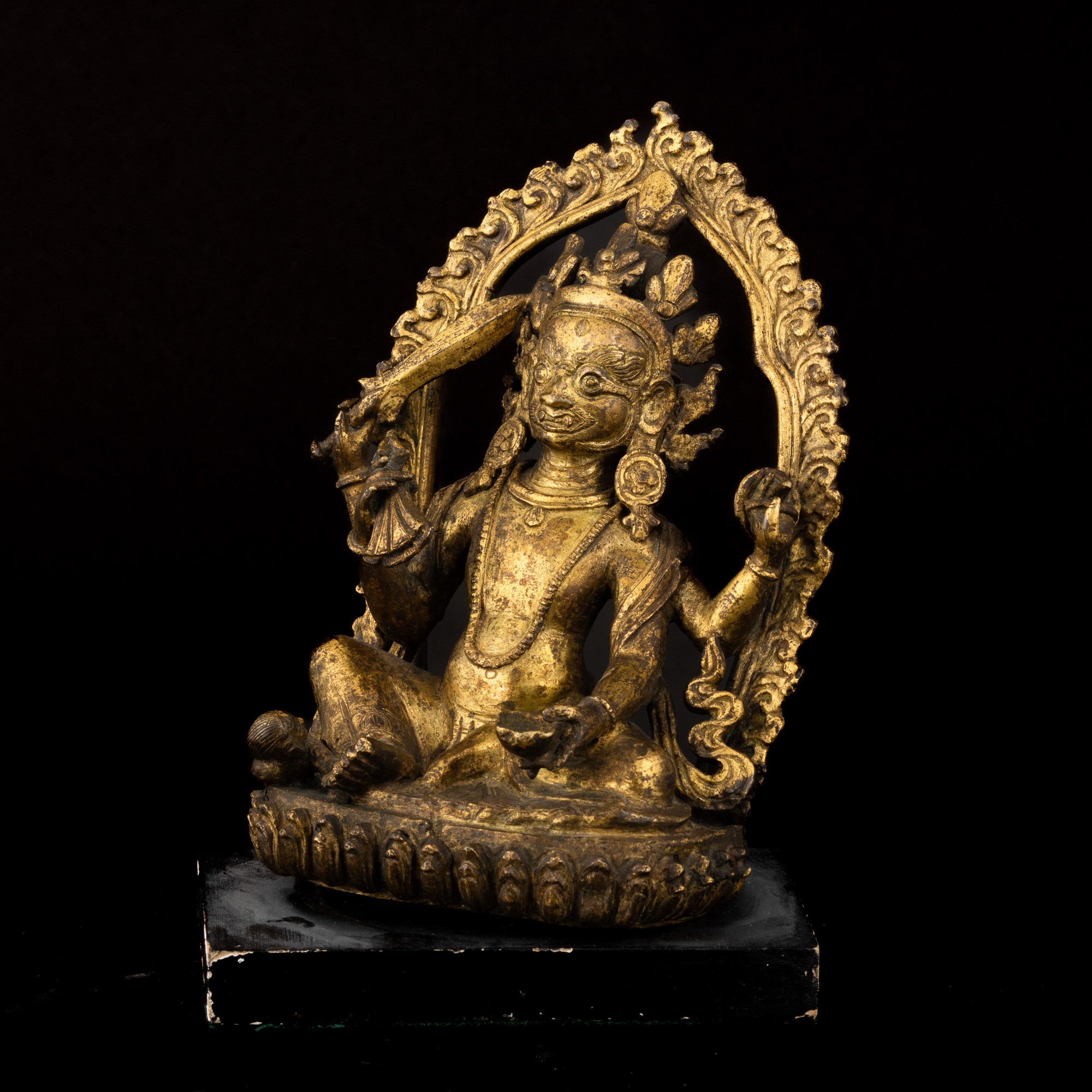 Figura di Mahakala Seduto su Fior di Loto Entro Aura in Bronzo Dorato, Nepal, XVII Secolo