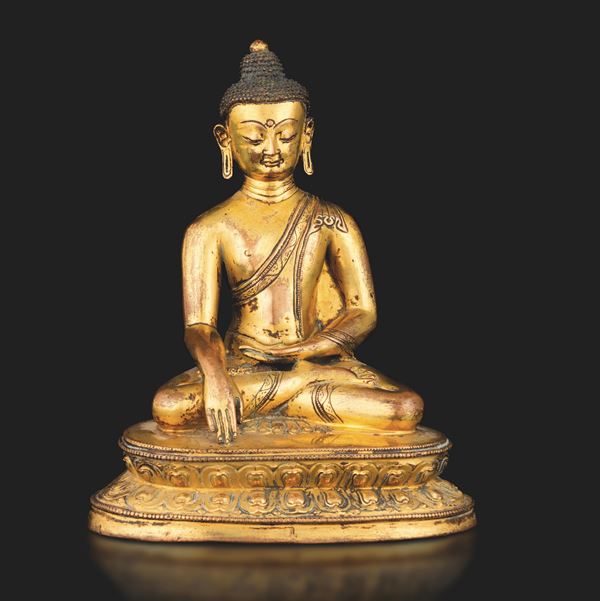 Figura di Buddha Sakyamuni seduto su doppio fiore di loto in bronzo dorato con tracce di policromia, ossidazione e dorature, Tibet, XVII secolo