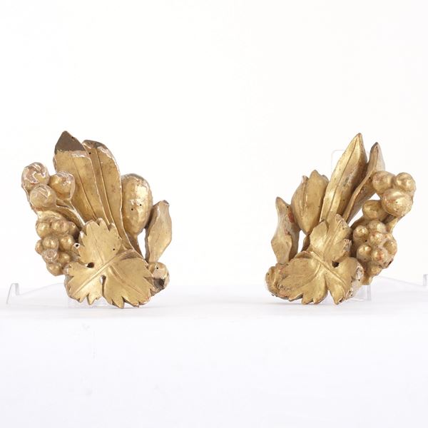 Due antichi frammenti di fregio in legno dorato, a foggia di foglie e frutti