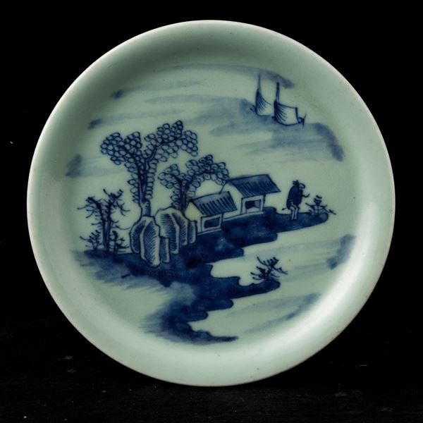 Piatto in porcellana Celadon con decoro in blu cobalto raffigurante paesaggio montano, Cina, Dinastia Qing, XIX secolo
