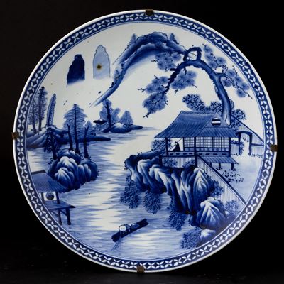 Grande piatto in porcellana bianca e blu raffigurante paesaggio montano, Giappone, XIX secolo, di...