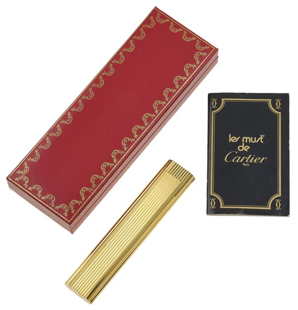 Gold plated lighter. Signed and numbered Cartier Paris n. F76599. Fitted case