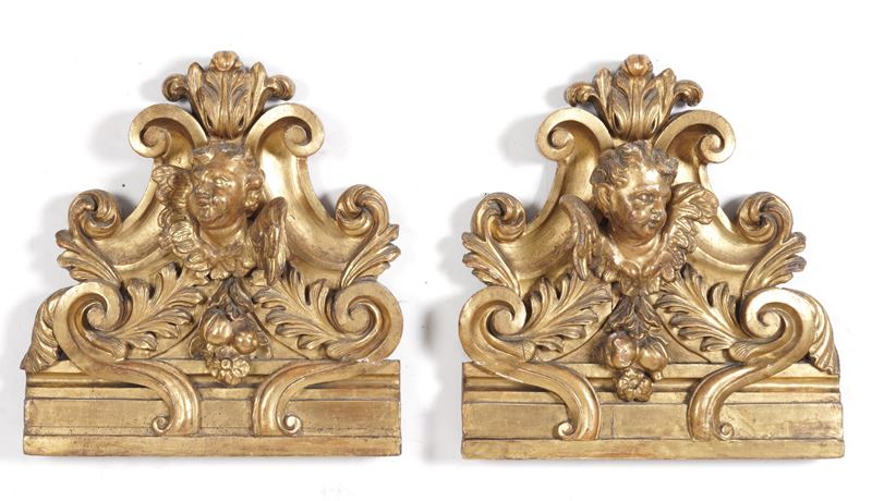 Coppia di elementi decorativi in legno intagliato e dorato a volute e cherubini. XVIII secolo  - Asta Scultura - Cambi Casa d'Aste