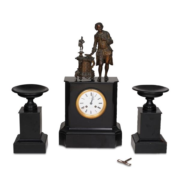 Trittico in marmo nero composto da due vasi e un orologio sormontato da figura maschile in metallo. XIX-XX secolo