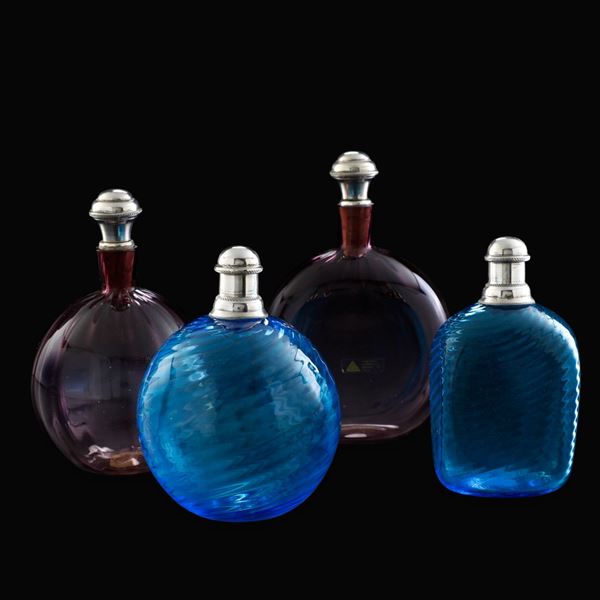 Quattro bottiglie. Murano, Cenedese & Albarelli, anni ‘90 del XX secolo.  Corpo nella tonalità del verde con tappo decorato in vetro trasparente, etichetta originale, firma incisa alla base, H cm 28  4 bottiglie (altezze cm: 20; 18; 15; 15)