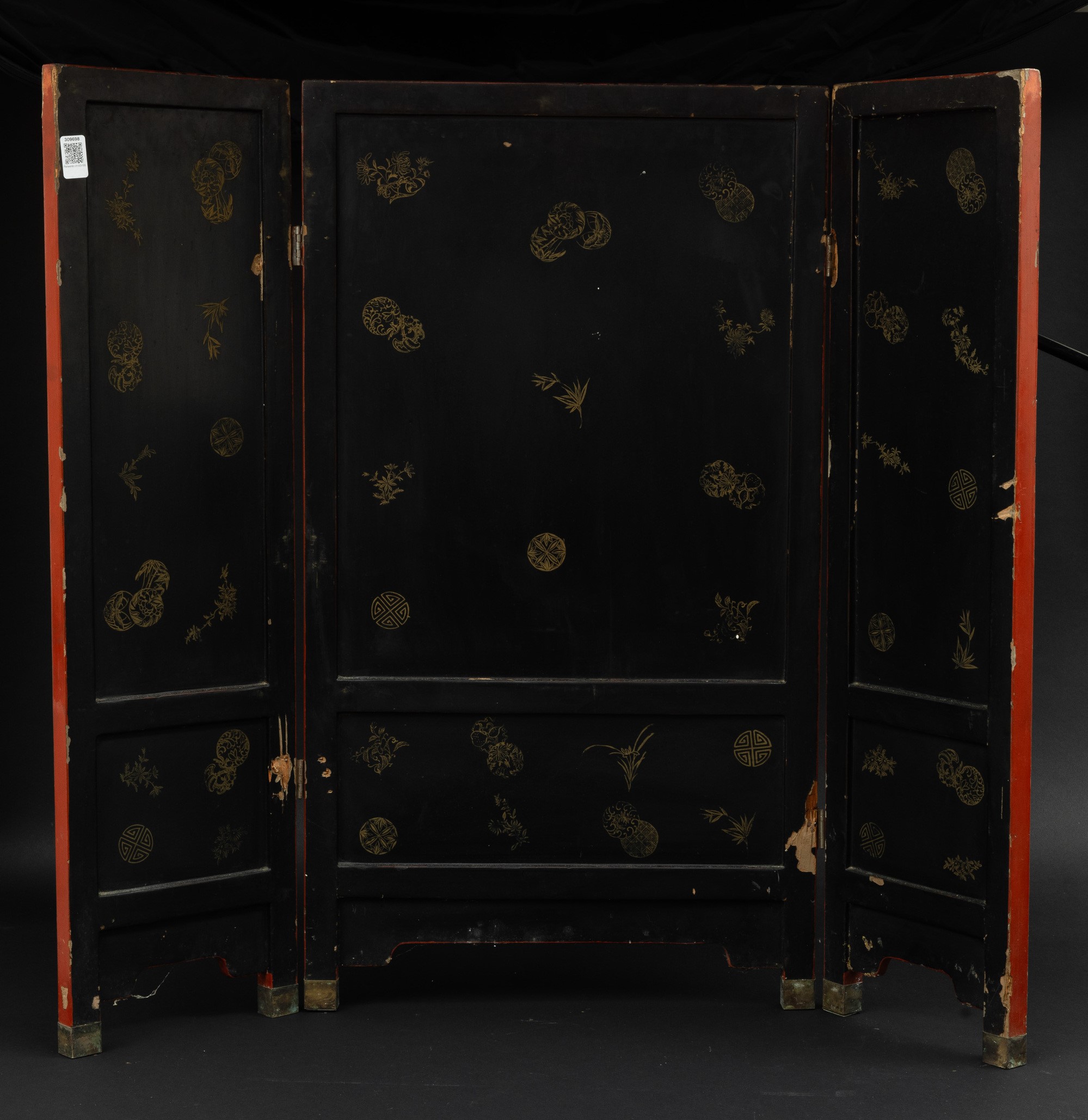 Paravento a tre ante in legno rosso laccato e applicazioni in pietre dure raffigurante scene di v...