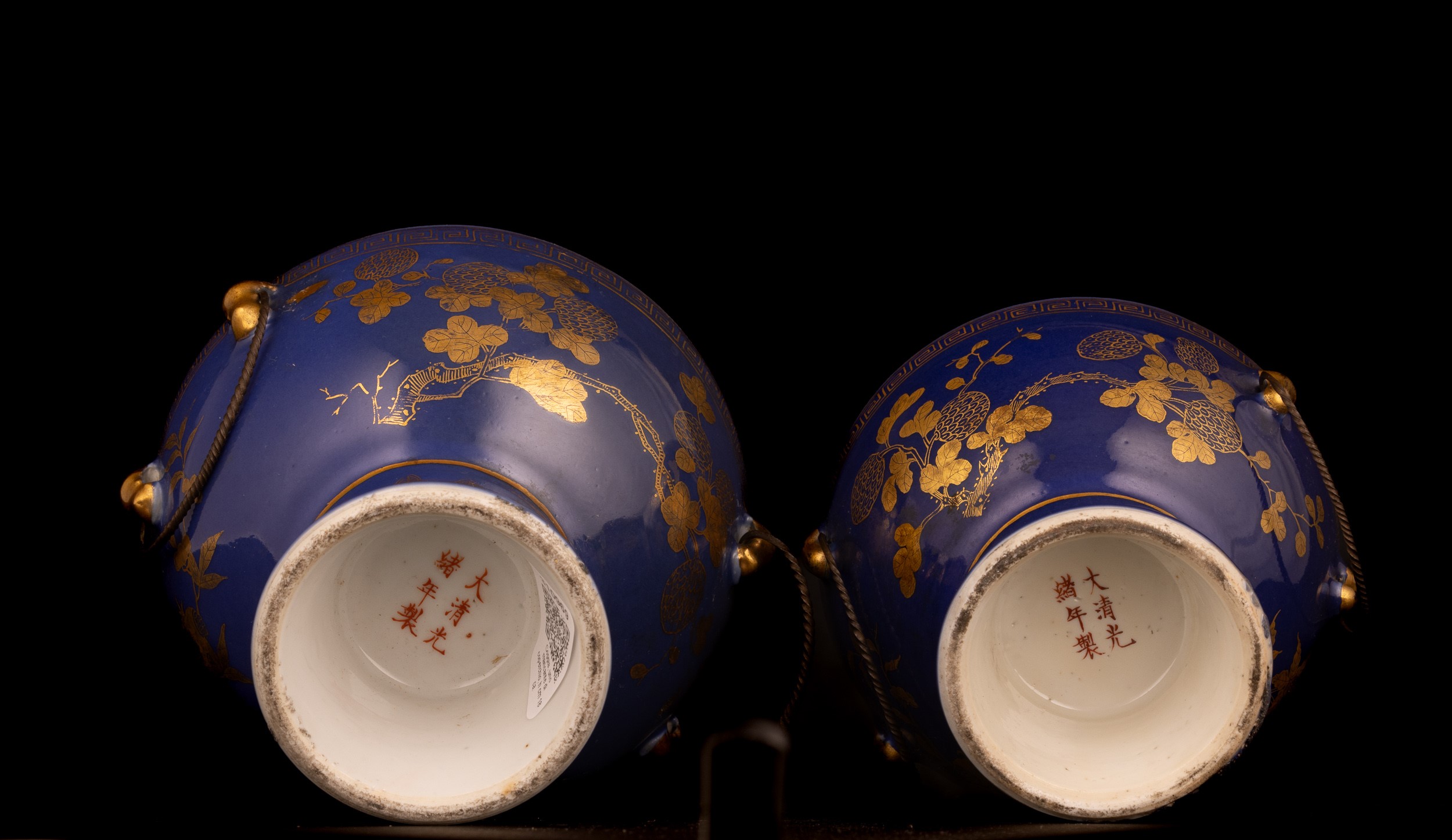 Cina, Coppia di ciotole in porcellana a fondo blu decorato con motivi floreali dorati, una con co...
