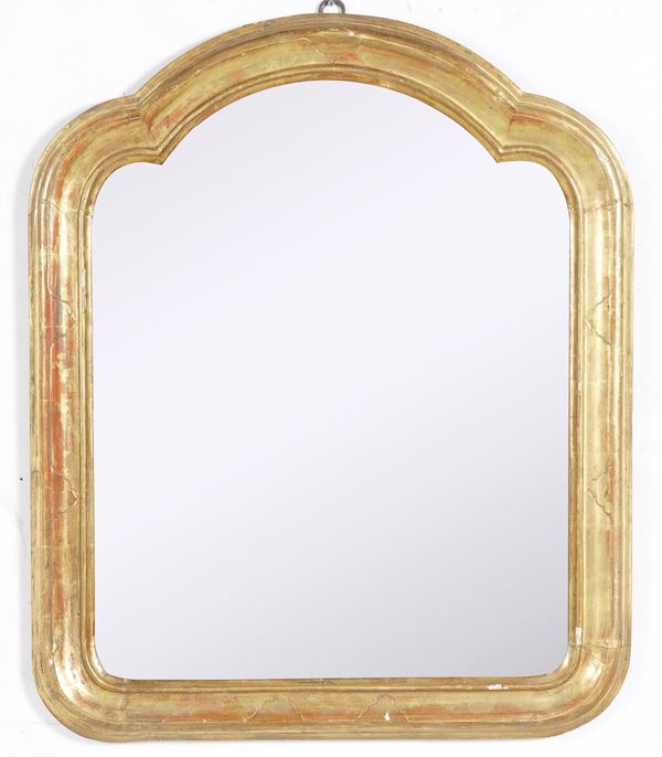 Specchiera centinata in legno intagliato e dorato. XIX secolo