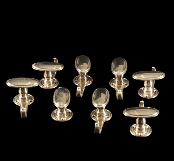 Gruppo di otto appendiabiti in ottone. XX secolo