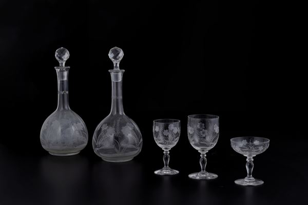 Servizio incompleto di bicchieri in vetro inciso con due bottiglie con tappo