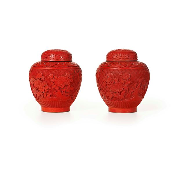Coppia di potiche in legno laccato rosso con decori a motivi floreali intagliati, Cina, XIX secolo