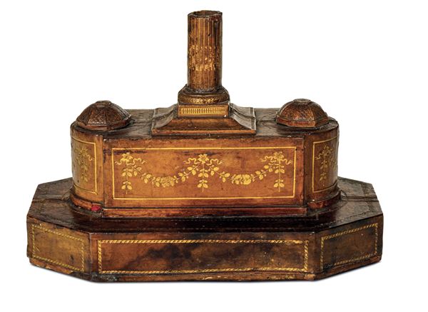 Calamaio in legno rivestito in cuoio impresso decorato a festoni e profilato in oro. XIX secolo