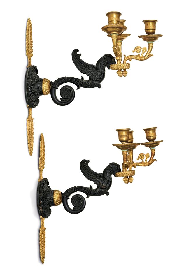 Coppia di appliques a tre luci in bronzo brunito e dorato. XIX secolo