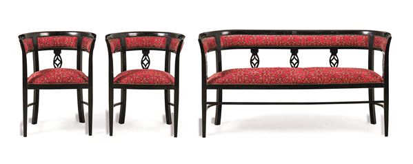 Divano e coppia di poltrone in legno ebanizzato. XX secolo