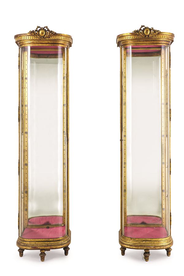 Coppia di vetrine in legno intagliato e dorato. XIX-XX secolo angoli smussati, pareti in vetro e cappello decorato con festone centrale