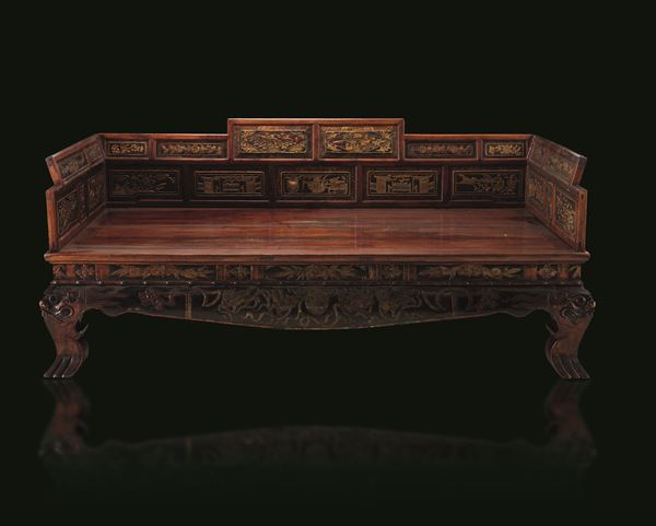 Camphor wood sofa/bed carved with gilding and inscriptions, panels depicting scenes of common life and nature scenes, dragon-shaped legs, China, Qing Dynasty, 19th century