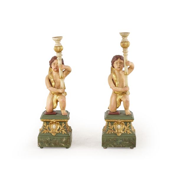 Coppia di angeli porta cero in legno laccato e dorato e resina. XX secolo